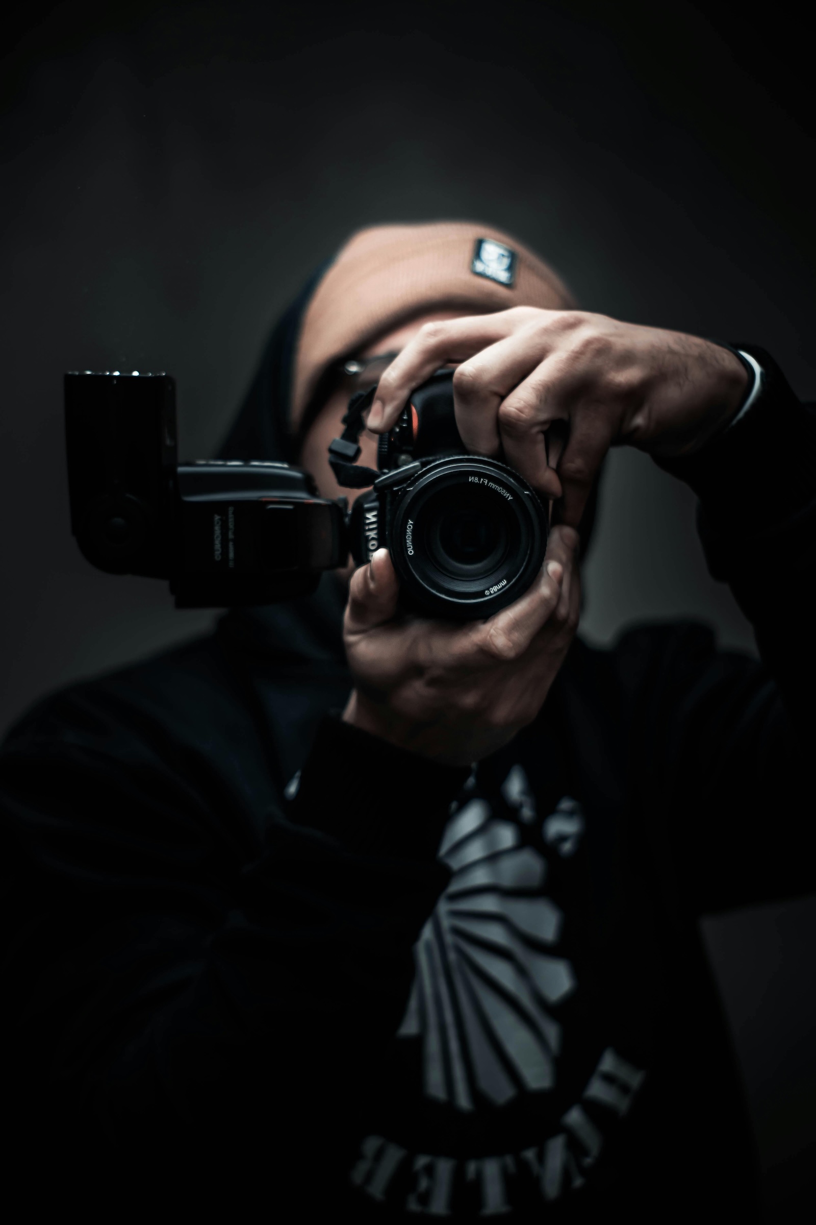 close up of camera lens held by canadian man wearing toque